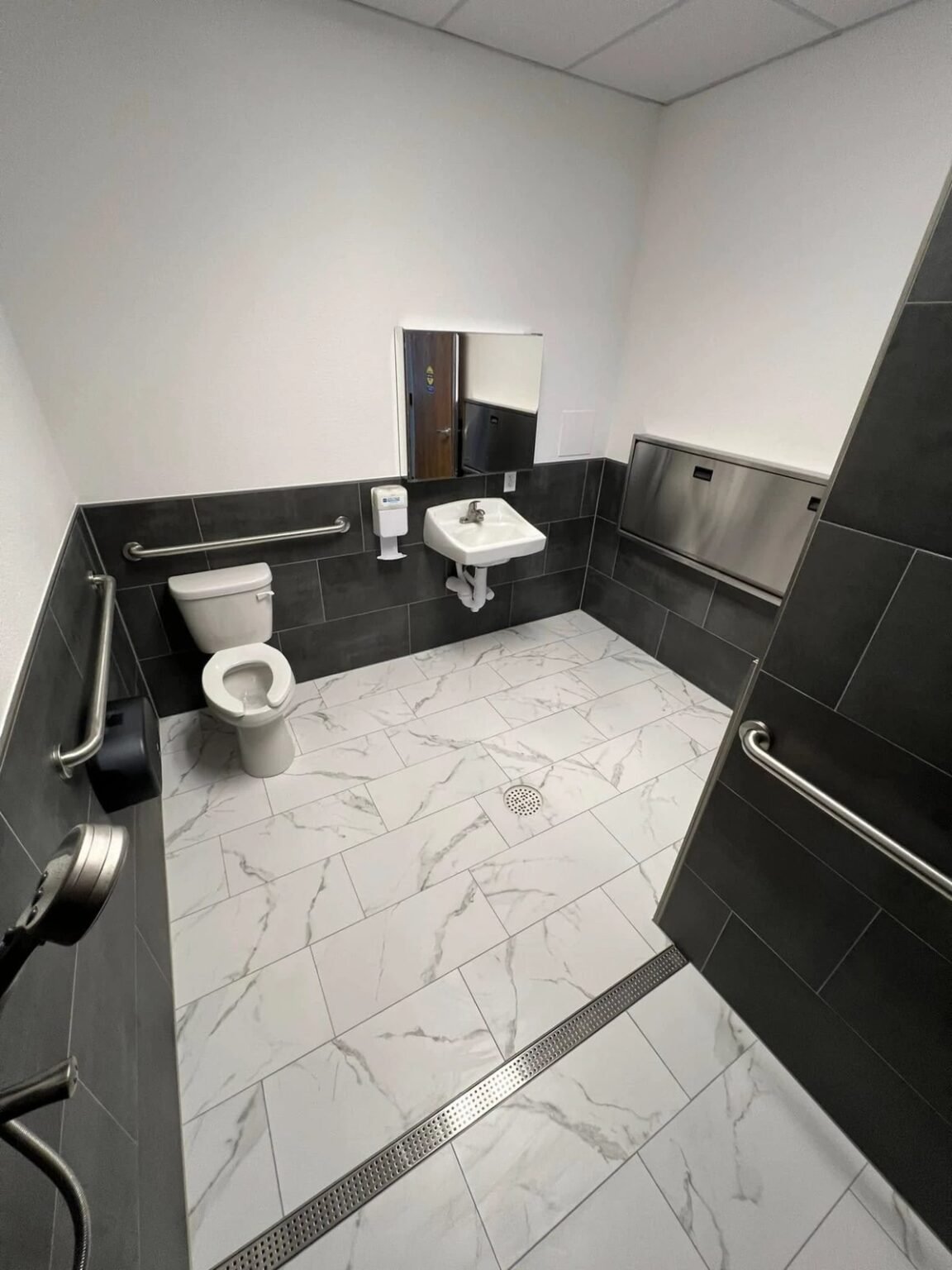 ADA-compliant restroom with grab bars, a wall-hung sink and a curbless roll-in shower entry with a linear drain, Mesa, AZ